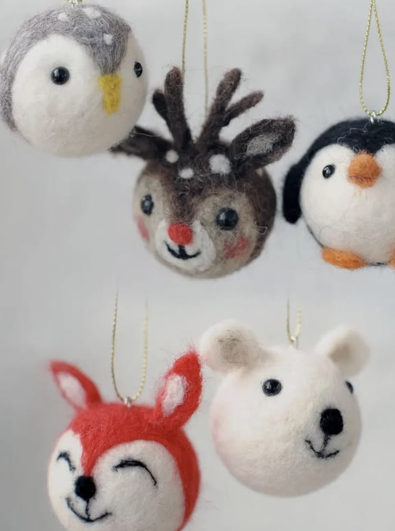 Five handmade felt animal ornaments hang on strings: bird, reindeer, penguin, fox, and polar bear.